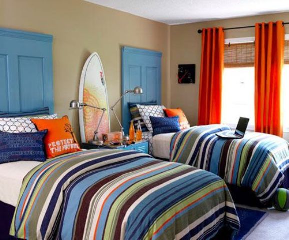 a bright surfing teen boy bedroom with door headboards, surfs, colorful textiles and bedding