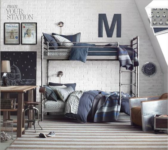 a modern industrial shared teen bedroom with metal bunk beds, metal and wooden furniture, a gallery wall and a striped rug