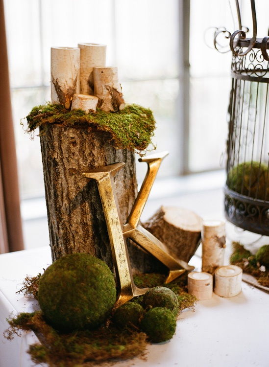 a cool spring centerpiece of moss, a monogram, a tree stump with candles is a chic rustic idea