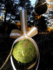 a moss ball with a burlap bow is a cool decoration for spring, hang it anywhere you like