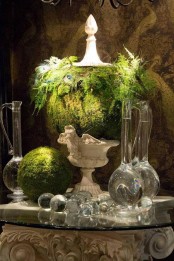 a quirky centerpiece of a vintage urn, a moss ball, some greenery and a moss ball next to it for a spring wedding