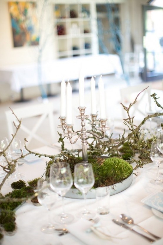 a spring centerpiece of a tin bowl, moss, branches and a chic vintage candelabra with candles