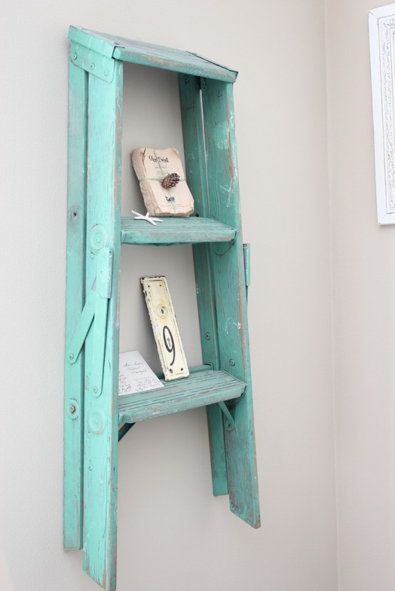 a turquoise ladder wall-mounted shelf with various decor is a creative idea to display your stuff and repurpose an old ladder at the same time