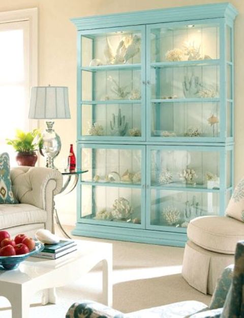 a gorgeous lit up turquoise glass cabinet for displaying variouc corals and other sea stuff is a great idea for a seaside or coastal home