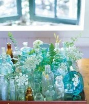 a tray with turquoise and green bottles and vases and some blooms is a lovely decor idea for any space, it’s bold and cool and will add interest to your room