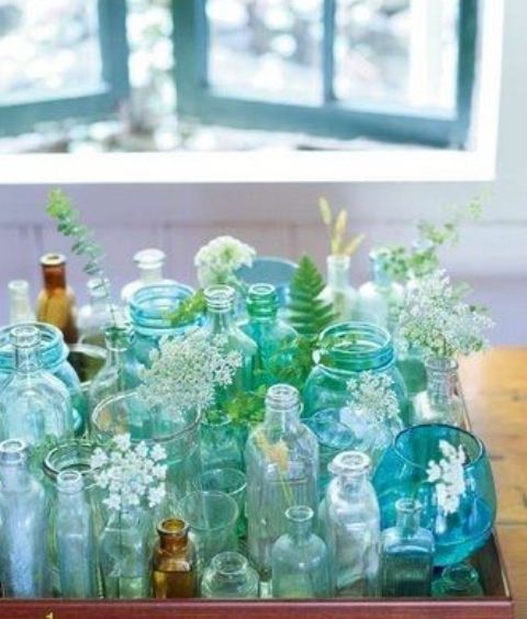 a tray with turquoise and green bottles and vases and some blooms is a lovely decor idea for any space, it's bold and cool and will add interest to your room