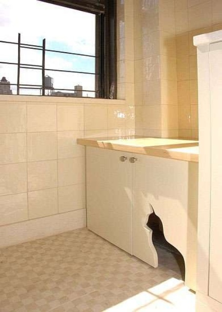 a neutral cabinet with a cat cutout for entrance and a cat litter box inside is a stylish and simple solution