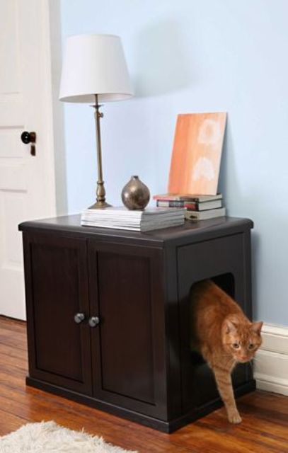 a dark stained cabinet with various items on top and a cat litter box inside is a cool idea for any space