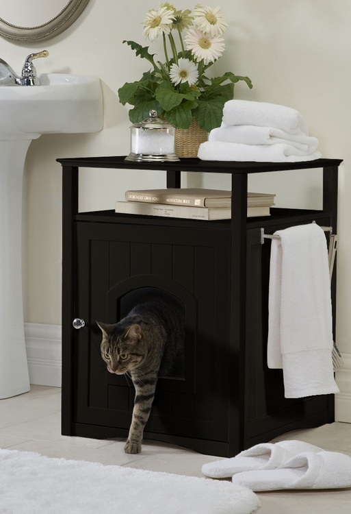 a black storage coffee table with an entrance and a cat litter box and some usual human stuff on top