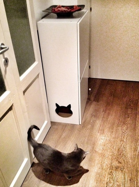 a tall white cabinet with a cat head-shaped entrance and a cat toilet inside is perfect to save some space