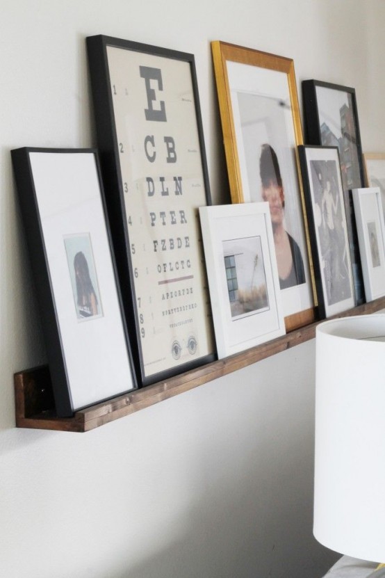 a wooden ledge with lots of artworks and photos is a lovely idea to create your own gallery wall with minimal effort