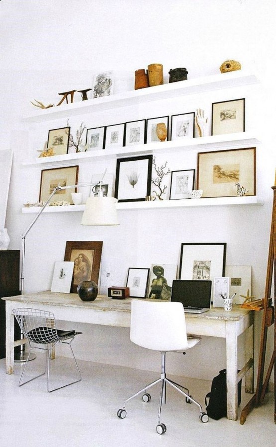 a work space with ledges over the desk, with branches, artworks, vases, antlers and skulls for personalizing the space and making it bolder and cooler