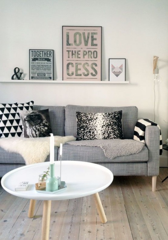 a welcoming Nordic living room with a long ledge along the wall that is used for a modern gallery wall - an edsy idea to spruce up the space