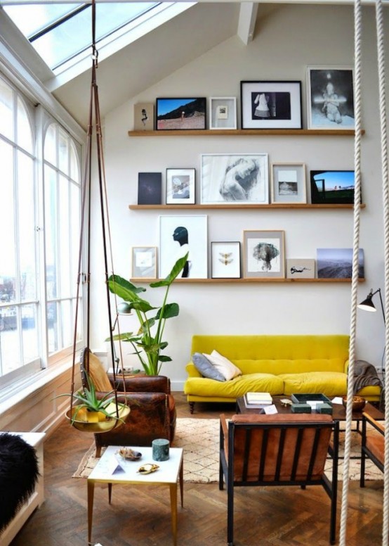 a bold double-height living room with lots of natural light, bold furniture, ledges with cool and bold artworks plus potted plants and greenery