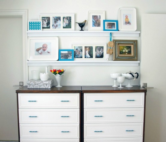 white ledges over the dressers create a whole wall gallery with various artworks and photos and it brings coziness here
