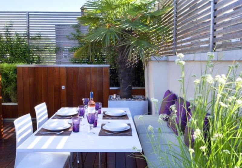 a modern dining space done in white and purple, with potted greenery and some blooms is very welcoming