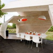 an ultra-modern dining space under a wooden roof in a neutral color, with pendant lamps and with white dining set