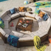 a modern round conversation put with colorful pillows and blankets plus small crate coffee tables in the center