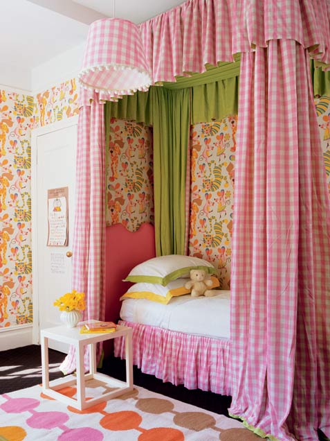 a dreamy country girl's room with bright floral wallpaper, a canopy bed in pink and neutrals, gingham curtains and a bold printed rug