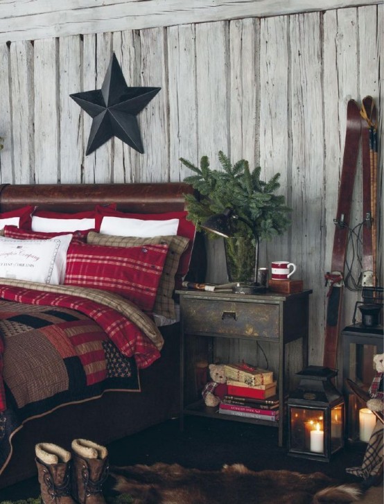plaid bedding, a faux fur rug, an evergreen arrangement and lots of candle lanterns for a cozy winter feel in the bedroom