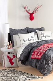 a faux red deer head, a deer pillow and some red bedding give a holiday feel to this neutral bedroom