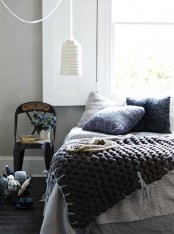 knit pillows in various shades, various knit and chunky knit blankets and a knit pendant lamp