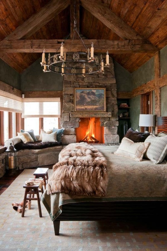 faux fur pillows and a blanket and a fireplace amek this bedroom an ultimate dream and relaxation oasis for winter
