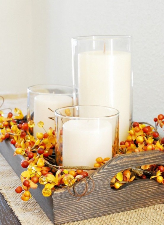 a wooden tray with berries and pillar candles is a very easy and very fall-like arrangement to rock
