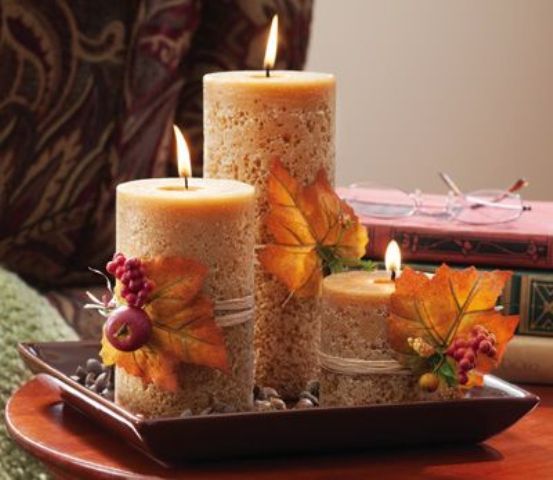 neutral pillar candles wrapped with bright fall leaves and berries will give you a cool fall centerpiece or just arrangement