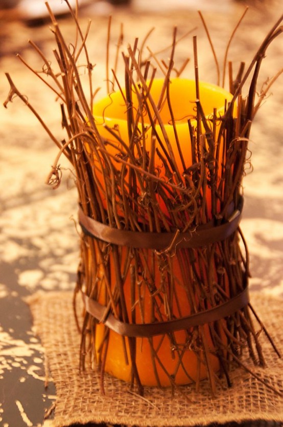 a candle with twigs and ribbon is a cool rustic fall decoration to use and you can DIY it last minute
