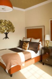 a fall colored bedroom with an orange bed, chocolate browns and muted greens plus neutrals