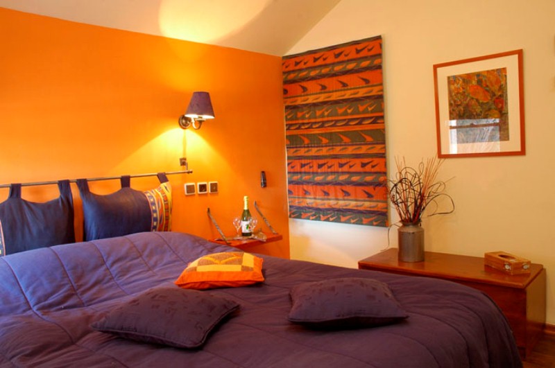 a bright fall bedroom done in orange, purple, greens and neutrals plus some fall patterns