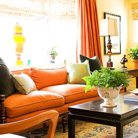 a bright orange sofa and a curtain will make your living room feel liek autumn