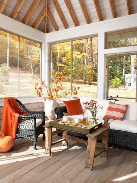 orange colored pillows and a blanket plus some fall leaf arrangements will make your home feel cozier during this season