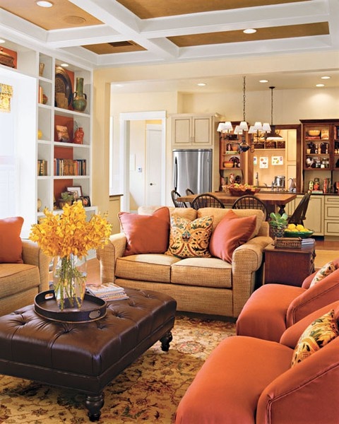 orange chairs and pillows will easily bring a fall feel to the space and a yellow bloom arrangement will help