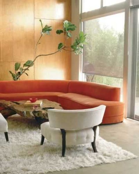 a curved orange sofa brings an autumn feeling to the space and makes it ultra-modern at the same time