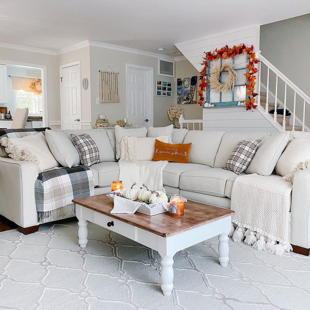 rust-colored curtaints, a rug and a striped sofa add fall aesthetics to the living room