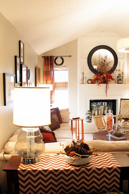 a bright striped orange curtain, a chevron runner and a fall arrangement on the mantel