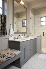 a modern farmhouse bathroom with penny and marble subway tiles, a grey vanity and a wooden frame mirror