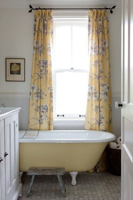a small farmhouse bathroom with a white vanity, a yellow clawfoot bathtub, yellow printed curtains a small farmhouse bathroom with a white vanity, a yellow clawfoot bathtub, yellow printed curtains