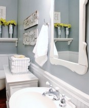 a grey and white farmhouse bathroom with white beadboard, a white sink and frame plus a vanity