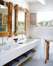 a tropical farmhouse bathroom with much white plaster and cocnrete, a double stone sink and rough wooden frames