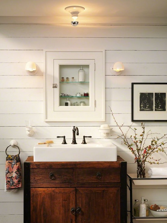 a white farmhouse bathroom with planks on the walls, a rich-stained wooden vanity and a built-in apothecary storage unit