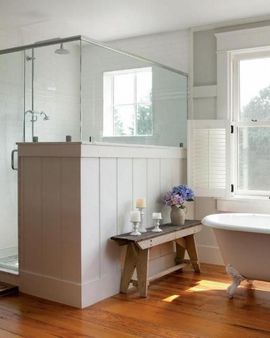 a cozy and light filled neutral farmhouse bathroom with a clawfoot bathtub, a shower partly clad with beadboard a cozy and light-filled neutral farmhouse bathroom with a clawfoot bathtub, a shower partly clad with beadboard