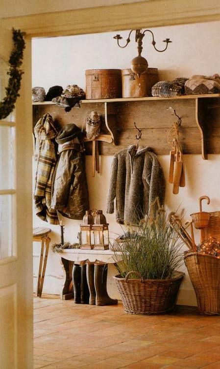 a cozy rustic entryway with a large wooden rack, some benches and baskets, a chandelier and a lanterns