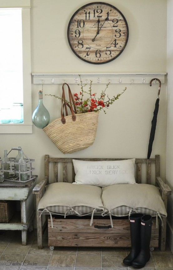 a farmhouse entryway with a wooden bench, a box on casters, a wooden clock and a rack with hooks