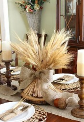 a wheat arrangement with a burlap bow on a wood slice is a lovely rustic decoration for the fall