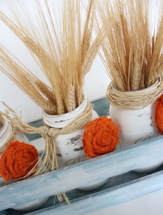 a chalked crate with white jars, orange fabric blooms and wheat is a chic and cozy centerpiece or decoration for a vintage farmhouse feel