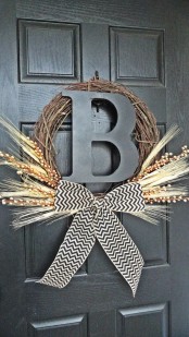 a rustic fall wreath of vine, a monogram, a chevron bow, willow and wheat is a fit for a farmhouse