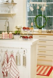plaid red and white linens, red and white candles and an evergreen wreath add a holiday feel to the space